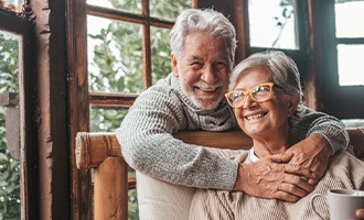 an older couple smiling while at home