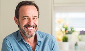 a man smiling with new dentures at home