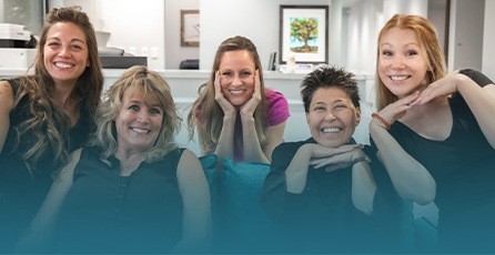 Westminster dentist and team members smiling in dental office reception area