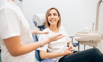 Smiling patient discussing questions with dental team member