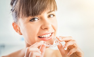 Woman placing Invisalign tray