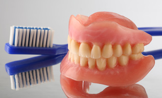 A full set of dentures and a toothbrush 