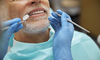 Man receiving a dental checkup for dentures 