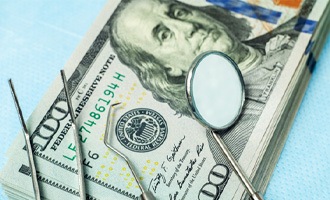 dental instruments sitting atop a stack of money