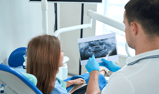 Patient listening to dentist in Westminster talk about tooth extraction