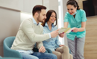 Dentist and couple discussing the cost of dental implants