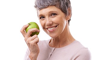 Smiling woman holding a green apple