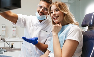 Young woman with her dentist marveling at her new dental implants