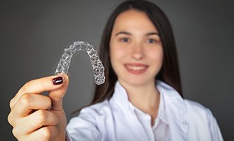 Woman holding Invisalign tray