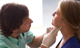 Doctor performing exam to check for signs of oral cancer