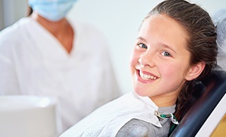 Smiling young girl in dental chair