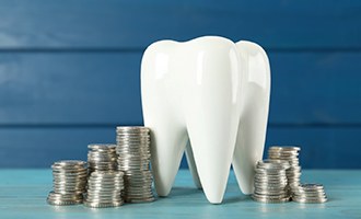 a big white tooth surrounded by coins