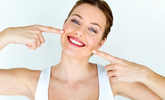 a woman in Westminster pointing at her whitened teeth 
