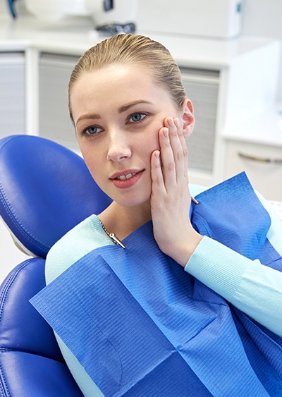 Young woman holding jaw in pain