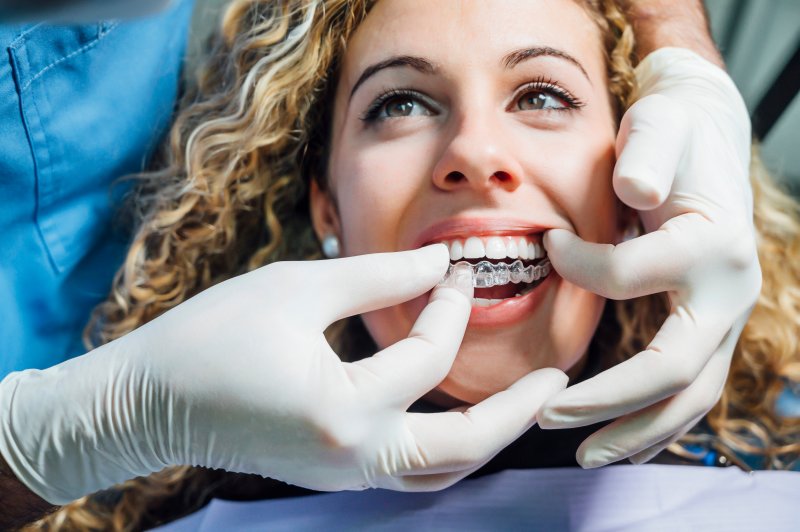 woman receiving Invisalign aligners