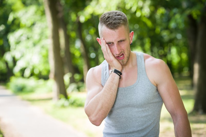 man exercising and experiencing tooth pain