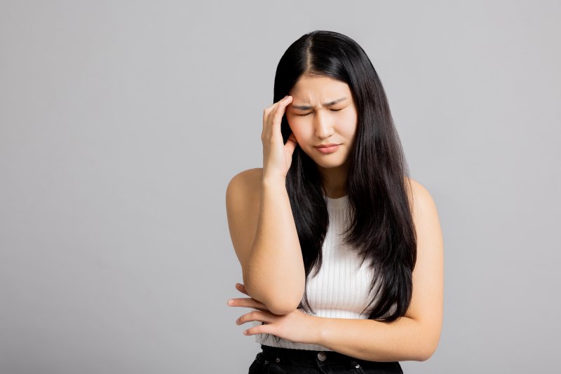 a woman touching her head due to a migraine