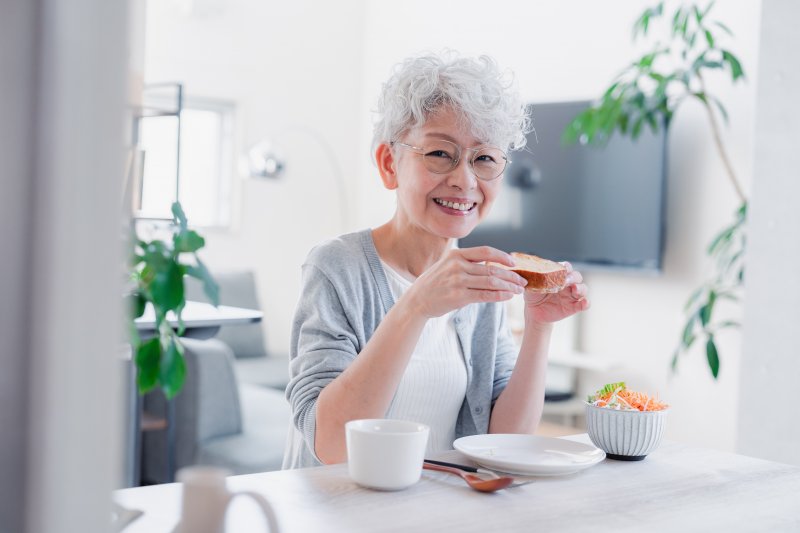woman with dentures eating a meal