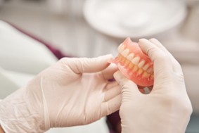 dentist holding a full set of dentures