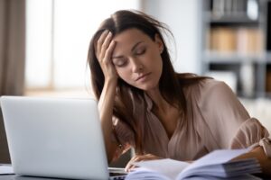woman sitting at her computer with her eyes closed